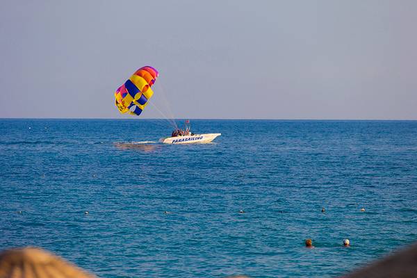 Farbiges Parasailing-Segel von einem Boot im Meer gezogen, Eftalia Aqua Resort