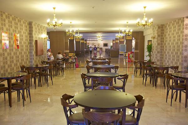 Eftalia Aqua Resort Hotel Innenbereich mit vielen Tischen und Stühlen, gemusterten Wänden und Kronleuchtern.
