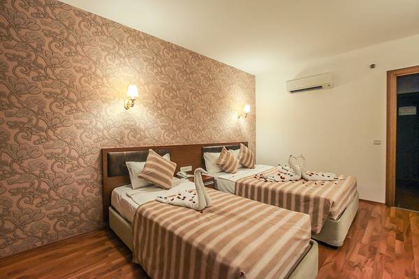 Hotelzimmer im Eftalia Aqua Resort mit zwei Betten, Bettwäsche und Schwänen aus Tüchern.