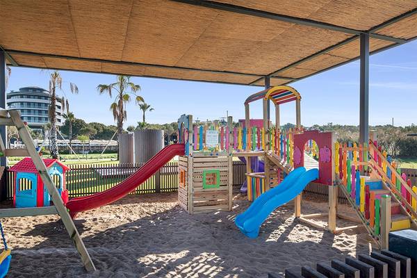 Kinderspielplatz im Voyage Belek Golf & Spa mit bunten Rutschen und Sandkasten.