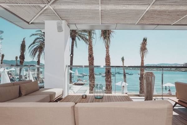 Aussicht von der Terrasse des Amare Beach Hotel Ibiza auf die Bucht und Palmen