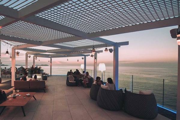 Hotelterrasse des Amare Beach Hotel Ibiza mit Blick auf das Meer und die Dämmerung.