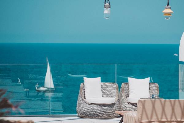 Terrasse des Amare Beach Hotel Ibiza mit Blick auf das Meer und eine Segelyacht