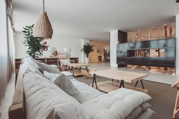 Wohnzimmer im Amare Beach Hotel Ibiza mit Sofa, Couchtisch und Korbstuhl