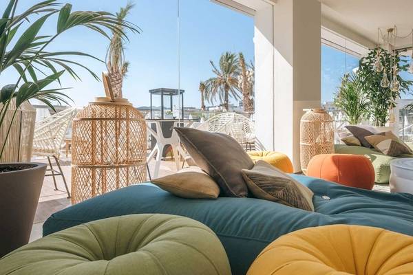 Loungebereich im Amare Beach Hotel Ibiza mit bunten Kissen und Pflanzen.