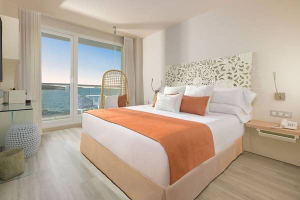 Zimmer im Amare Beach Hotel Ibiza mit Blick auf das Meer und eine Hängematte.
