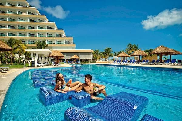 Paar im Riu Caribe Hotel neben dem Swimmingpool entspannend