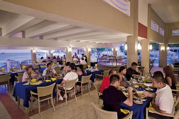 Gäste essen im Restaurant des Riu Caribe Hotels, mit Blick auf das Meer.