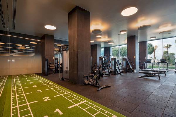 Fitnessstudio im Voyage Belek Golf & Spa Hotel mit moderner Ausstattung und Blick auf Außenbereich.