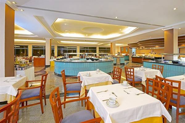 Innenansicht des Restaurants im Mirador Papagayo by LIVVO Hotel mit gedeckten Tischen und Buffet.