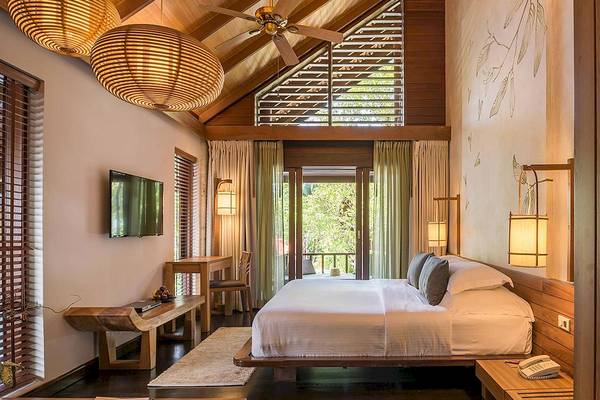 Schlafzimmer im Tubkaak Krabi Boutique Resort mit großem Bett, Fernseher und Balkon.