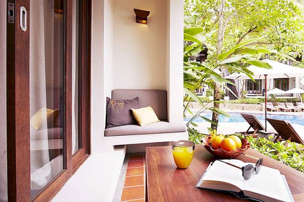 Balkon des Tubkaak Krabi Boutique Resorts mit Sitzecke und Blick auf den Pool.