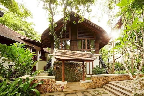 Außenansicht des Tubkaak Krabi Boutique Resorts, umgeben von Bäumen und Pflanzen.