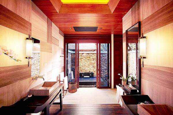 Innendesign eines Badezimmers im Tubkaak Krabi Boutique Resort mit Holzwänden und Fliesenboden.
