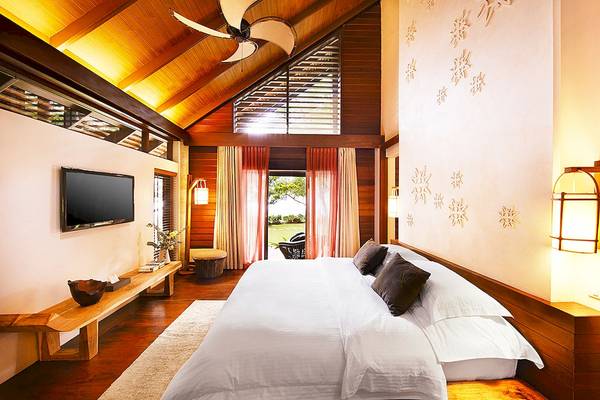 Schlafzimmer im Tubkaak Krabi Boutique Resort mit Bett, Fernseher und Holzmöbeln