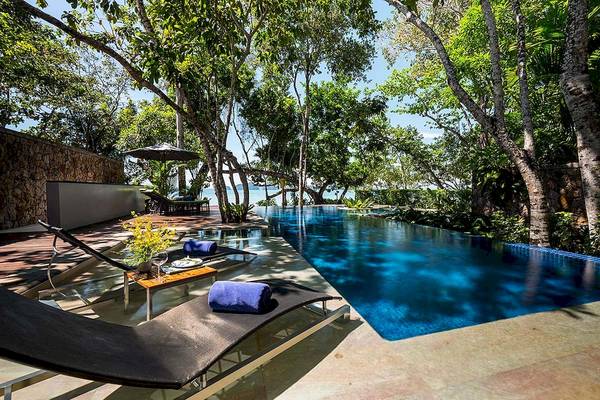 Außenpool und Terrasse des Tubkaak Krabi Boutique Resorts mit Sonnenliegen und grüner Umgebung