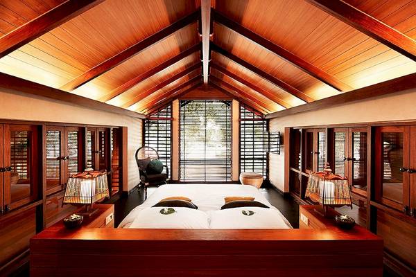 Schlafzimmer im Tubkaak Krabi Boutique Resort mit zwei Betten und Holzmöbeln.
