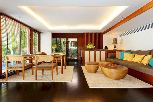 Innenbereich des Tubkaak Krabi Boutique Resorts mit Esstisch, Couch und Teppichen.