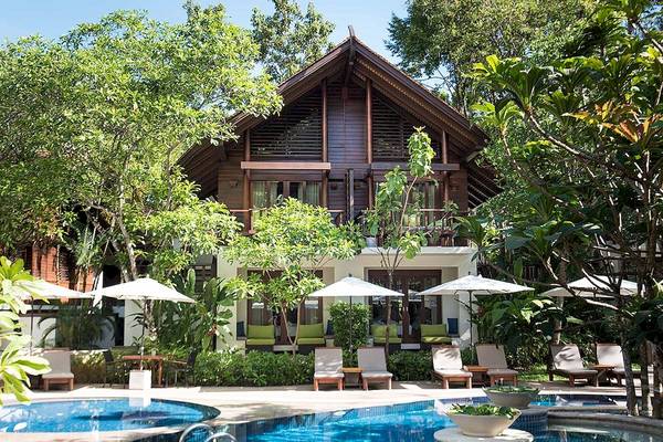 Außenbereich des Tubkaak Krabi Boutique Resorts mit Swimmingpool und Sonnenliegen.