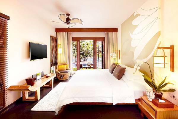 Das Schlafzimmer im Tubkaak Krabi Boutique Resort mit einem großen Bett, einer Fernsehwand und einer Glastür zum Pool.