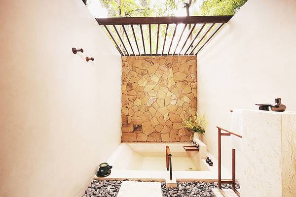 Badezimmer mit Badewanne und Steinwand im Tubkaak Krabi Boutique Resort