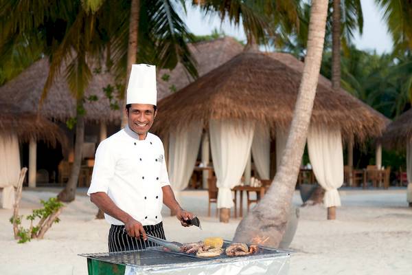Koch am Grill im Reethi Faru Resort mit Fleisch und Gemüse