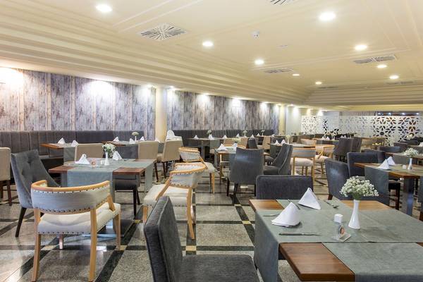 Restaurant des Sarena de Muro Resorts auf Mallorca mit gepolsterten Bänken und gedeckten Tischen.