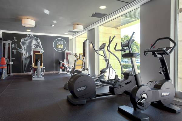 Fitnessstudio im Sarena de Muro Resort Mallorca mit Technogym-Geräten und Blick auf die Außenlandschaft.