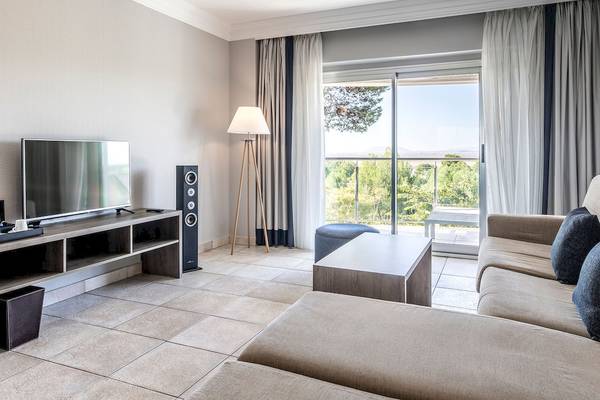 Wohnzimmer mit Fernseher, Lautsprechern, Couch und Fenstern im Sarena de Muro Resort Mallorca