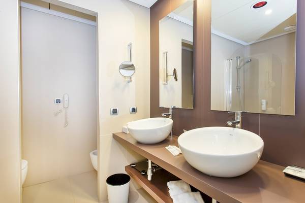 Badezimmer im Sarena de Muro Resort Mallorca mit zwei Waschbecken und Spiegeln.