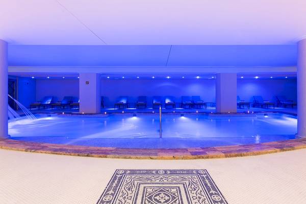 Innenpool des Sarena de Muro Resort Mallorca mit blauer Beleuchtung und Liegestühlen