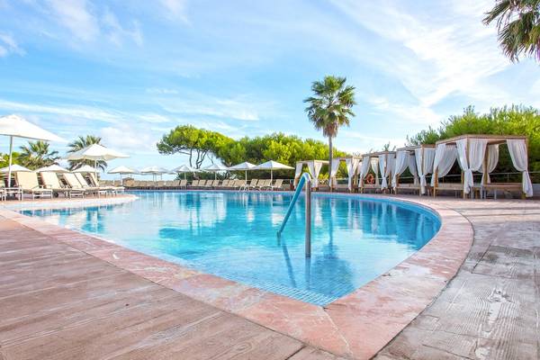 Außenpool des Sarena de Muro Resort Mallorca mit Sonnenliegen und Sonnenschirmen.