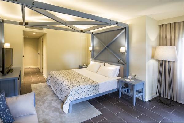 Hotelzimmer im Voyage Sorgun mit Bett, Nachttischen und Fernseher.