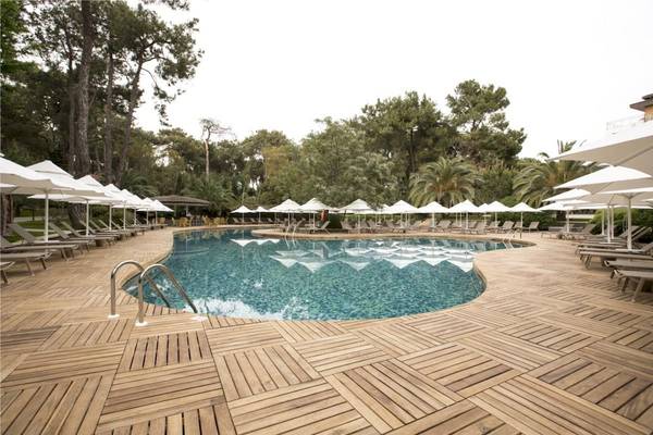 Poolbereich des Voyage Sorgun Hotels mit Liegen und Sonnenschirmen