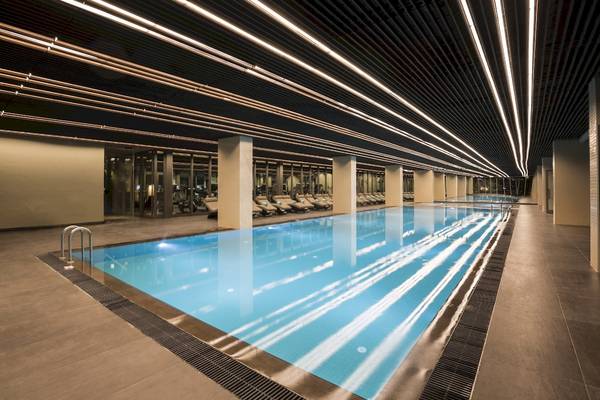 Ein großer Innenpool im Voyage Sorgun Hotel mit beleuchteter Decke und Loungebereich.