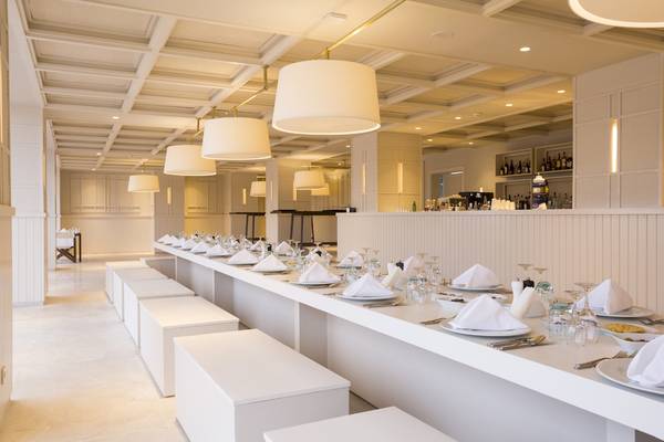 Innenansicht des Speisesaals im Voyage Sorgun Hotel mit langen Tischen und weißen Möbeln.
