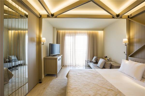 Schlafzimmer im Voyage Sorgun Hotel mit Fernseher, Couch und Spiegel