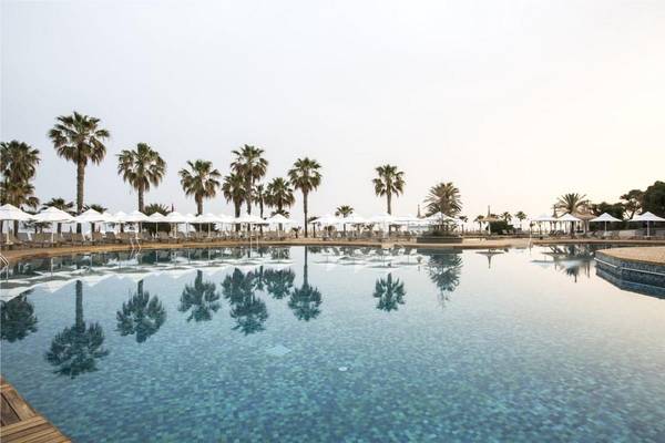 Außenpool des Voyage Sorgun Hotels mit weißen Sonnenschirmen und Liegestühlen