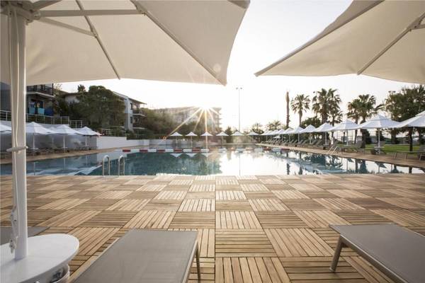 Poolterrasse im Voyage Sorgun Hotel mit Sonnenschirmen und Liegen