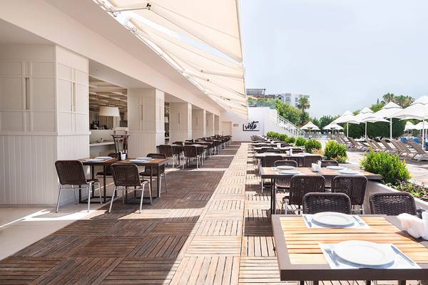 Terrasse des Voyage Sorgun Hotels mit vielen Tischen und Stühlen unter Sonnenschirmen.