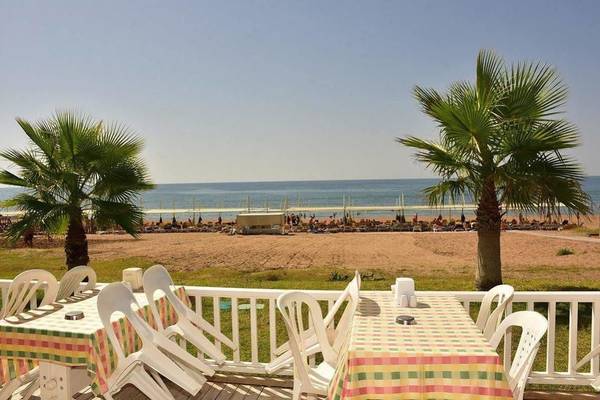 Terrasse des Victory Resort mit Tisch und Blick auf den Strand