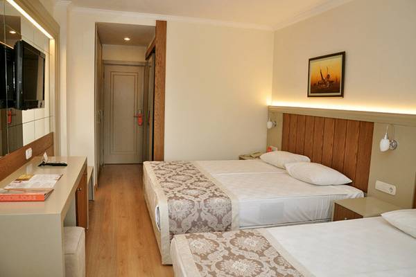 Doppelzimmer im Victory Resort mit zwei Betten, Fernseher, Schreibtisch und Lampe.