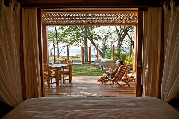 Bett mit Aussicht auf das Meer im Capitan Suizo Beachfront Boutique Hotel.