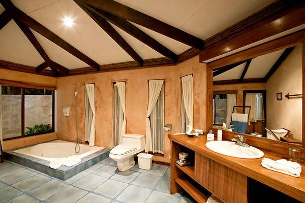 Badezimmer im Capitan Suizo Beachfront Boutique Hotel mit Badewanne, Toilette und Waschbecken.