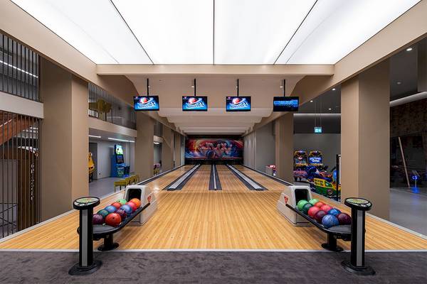 Innenansicht der Bowling-Halle im Voyage Belek Golf & Spa Hotel mit Bowlingbahnen, Ballrückgabesystem und Fernsehern.
