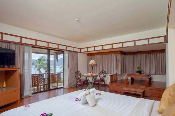 Innenansicht eines Seaview Patong Hotelzimmers mit Meerblick, Bett, Tisch und Fernseher.