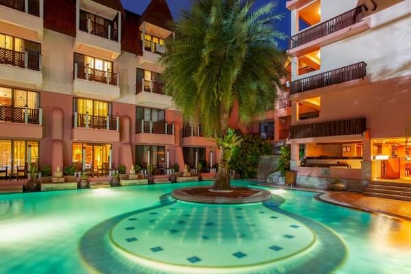 Außenpool des Seaview Patong Hotels mit tropischen Pflanzen und Gebäude im Hintergrund.
