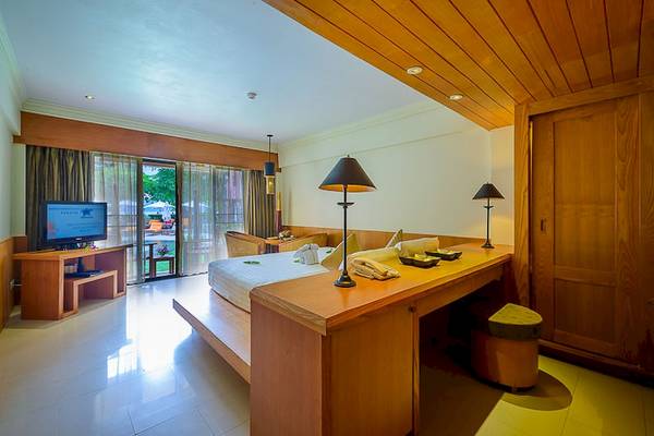 Innenansicht eines Zimmers im Seaview Patong Hotel mit Bett, Fernseher und Schreibtisch.