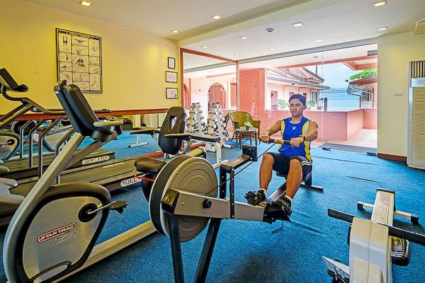 Fitnessbereich im Seaview Patong Hotel mit einem Mann auf einem Rudergerät.