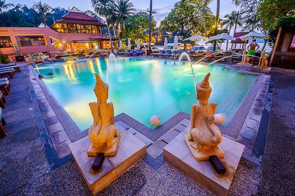 Nachtansicht des Pools des Seaview Patong Hotels mit Statuen und beleuchteten Gebäuden.